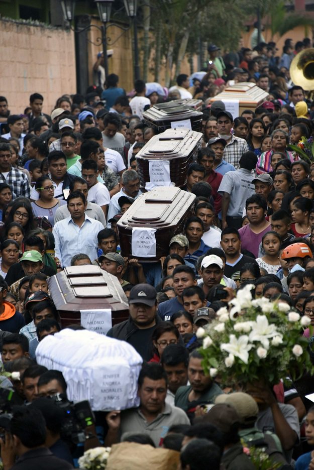 Residents carry the coffins of seven people who died following the eruption of the Fuego volcano, along the streets of Alotenango municipality, Sacatepequez, about 65 km southwest of Guatemala City, on June 4, 2018. Rescue workers Monday pulled more bodies from under the dust and rubble left by an explosive eruption of Guatemala's Fuego volcano, bringing the death toll to at least 62. PHOTO:AFP